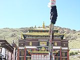 Tibet 07 03 Shigatse Tashilhunpo Kelsang Temple Courtyard The flag stoned great courtyard next to the Tashilhunpo�s Kelsang Temple. The courtyard walls, built in 1472, consist of rock slabs carried from a retreat west of Tashilhunpo. Carved on their surfaces are images of many Buddhas. The centre of the open yard has a special flagpole decorated with a white umbrella symbolizing spiritual victory.